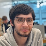 Headshot of me in the Apple Store wearing a grey hoodie